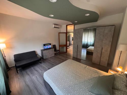 a bedroom with a bed and a chair and a mirror at Le due dimore del Baluardo in Novara