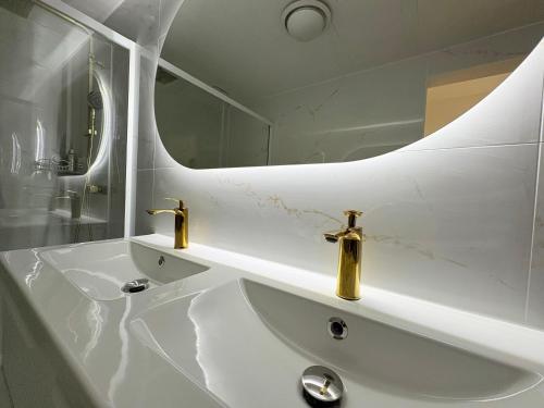 a white bathroom with a sink and a mirror at La Jungle du Vernet, Ambiance Tropicale in Le Vernet