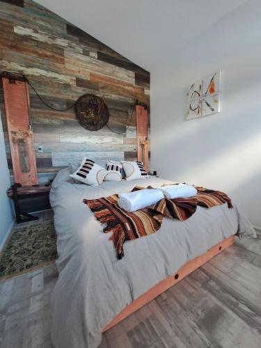 a bedroom with a large bed with a wooden wall at 4 Rest in a warm and comfortable loft in Coihaique