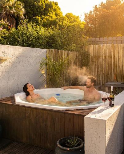 a man and woman sitting in a bath tub at Robin Retreat - Luxury 3 Bedroom Villa -Hermanus in Hermanus