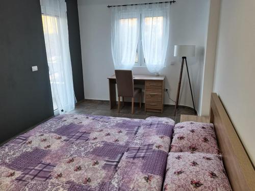 a bedroom with a bed and a desk and windows at Ninas Seaview Apartment in Bar