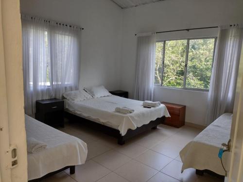 a bedroom with two beds and a window at Finca Hotel Campestre Salitre Villeta in Villeta