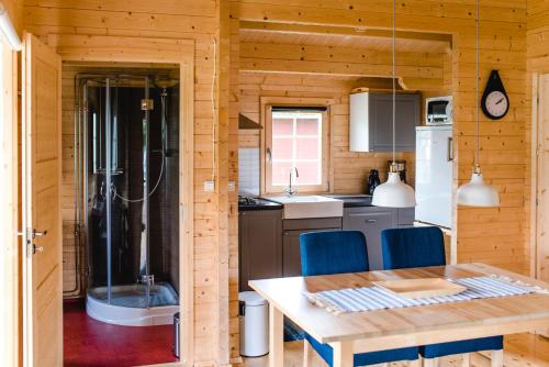 a kitchen with a table and blue chairs in a cabin at Alevi Camping in Stöllet