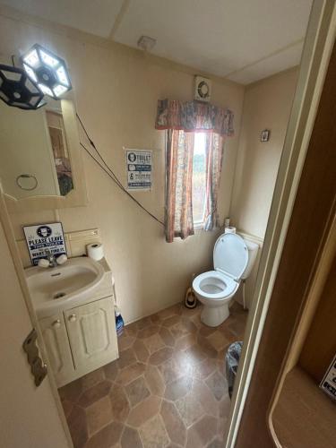 a small bathroom with a toilet and a sink at Ready Pitched Tent stay Bring your own bedding in Trefnant