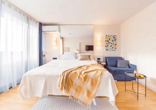 a bedroom with a large bed and a blue chair at New Orbi City Luxury Suites in Batumi