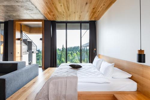 a bedroom with a bed and a large window at Шпиці boutique hotel & SPA in Yablunytsya