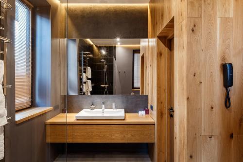 a bathroom with a sink and a mirror at Шпиці boutique hotel & SPA in Yablunytsya