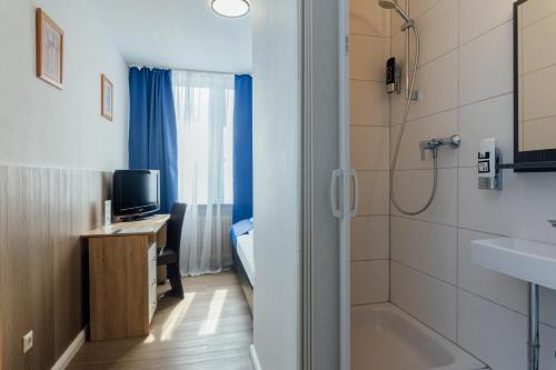 a bathroom with a tub and a sink and a desk at Hotel Hanseat Hamburg - Free Parking in Hamburg