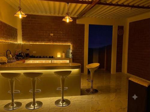 a kitchen with a counter and stools in a room at Villa Arcoíris in Paita