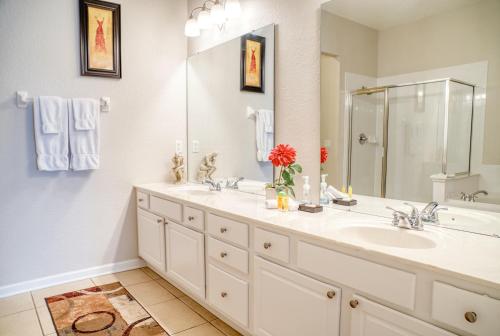 a bathroom with two sinks and a large mirror at Vista Cay Luxury Loft in Orlando