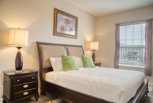 a bedroom with a bed with two lamps and a window at Vista Cay Luxury Loft in Orlando