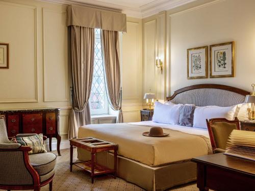 a hotel room with a bed with a hat on it at Hotel de la Cité Carcassonne - MGallery Collection in Carcassonne