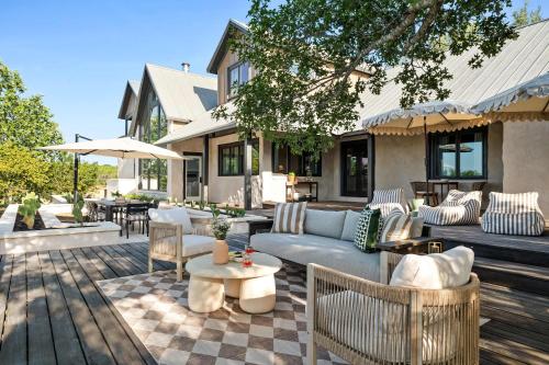 a patio with a couch and chairs and tables at Sunset Ridge Ranch - Pool Outdoor Kitchen & Views in Dripping Springs