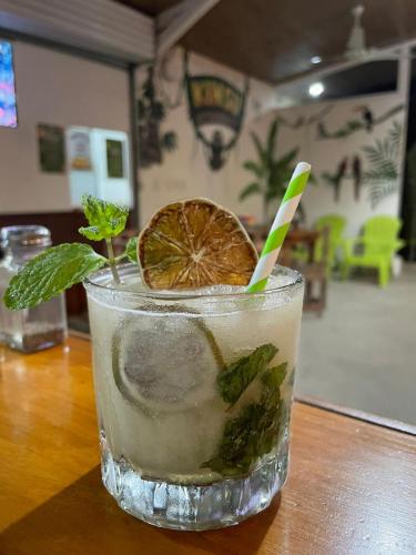 a drink with an orange slice and mint on a table at Karandi Hostel Uvita in Uvita