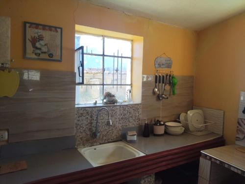 a kitchen with a sink and a window at Casa de campo y Chalet las Morenas in Sicuani