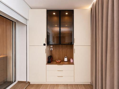 a kitchen with white cabinets and a curtain at Le Ramo - Résidence Ramoflores in Sidi Rahal