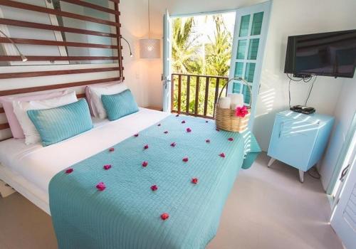 a bedroom with a bed with flowers on it at Praiagogi Boutique Pousada in Maragogi