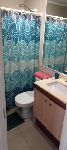 a bathroom with a toilet and a shower curtain at depto nuevo temuco in Temuco