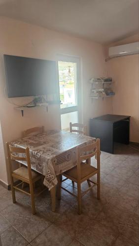 a dining room with a table and chairs and a window at Apartman Andrej in Bar