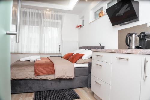 a small bedroom with a bed and a kitchen at Alvastay - Cozy studio in Haaltert