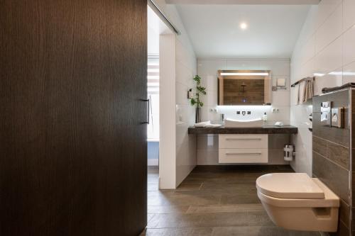 a bathroom with a toilet and a sink at Hof van Alexander Boutiquehotel in Renesse