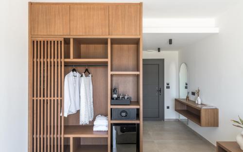 a room with a closet with wooden shelves and a sink at Serenya Hotel Milos in Adamantas