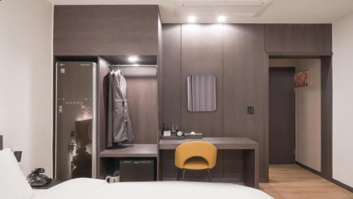 a bedroom with a desk and a yellow chair at HOTEL lantana in Tudomi