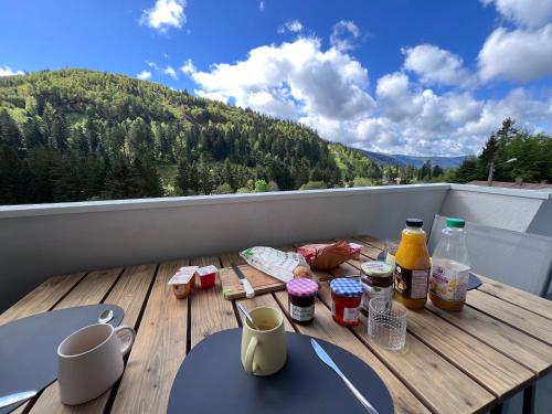 a table with food and drinks on a balcony at Le Balcon - La Bresse in La Bresse