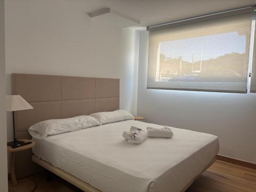 a bedroom with a bed with two towels on it at Apartamentos La Reserva Isla "Playa de la Cava" in Isla
