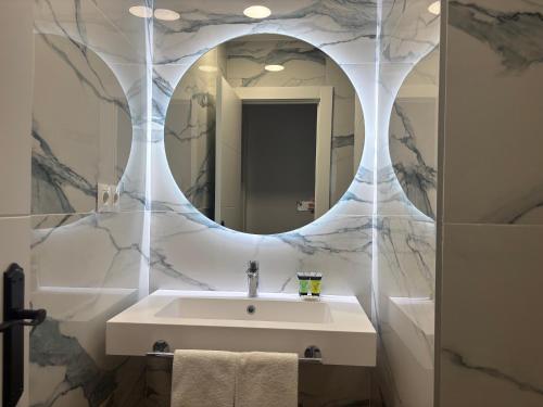 a bathroom with a white sink and a mirror at Apartamentos La Reserva Isla "Playa de la Cava" in Isla