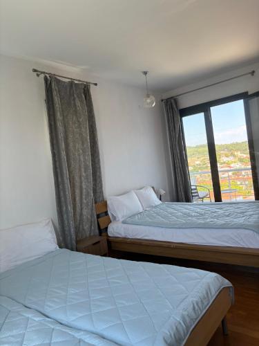 two beds in a room with a window at BLUE HOUSE in Paliouri