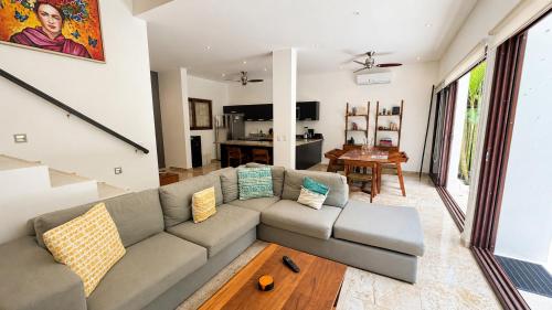 a living room with a couch and a table at Townhome with private Rooftop & Jacuzzi - Beach across street in Akumal