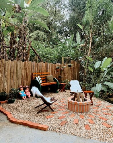 a garden with a bench and a fence at Cabana com Cachoeira Privativa in Imaruí