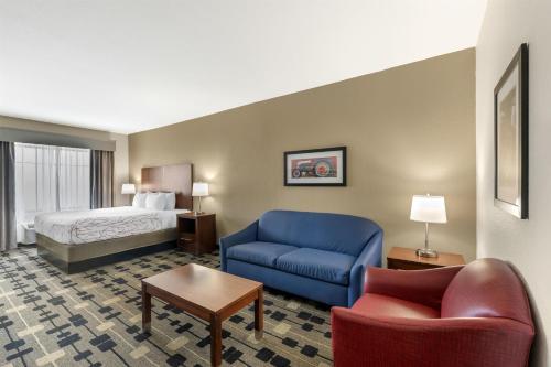 a hotel room with a bed and a blue couch at Best Western Plus Big Lake Inn in Big Lake