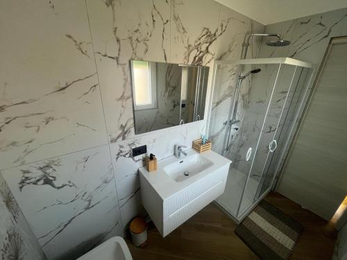 a white bathroom with a sink and a shower at Cantalupo30 in Cantalupo