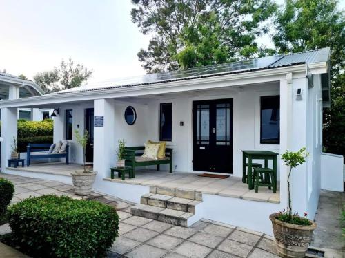 a small white house with a patio at Bergview Guesthouse Swellendam in Swellendam