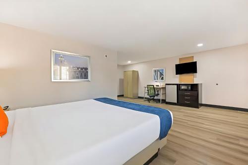 a hotel room with a large bed and a desk at Pasadena Inn at Old Town, Los Angeles in Pasadena
