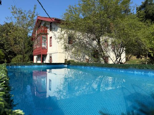 a house and a swimming pool in front of a house at Lutzin Etxea, Caserío Vasco con piscina, jardín y parking, a 15 min de Bilbao in Llodio