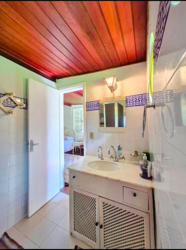 a bathroom with a sink and a mirror and a shower at Pousada dos Chalés - Araras in Araras Petropolis
