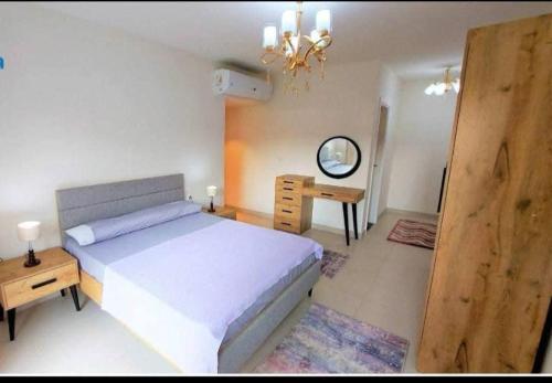 a bedroom with a large bed and a desk at Chalet Marina 2 Marassi in El Alamein