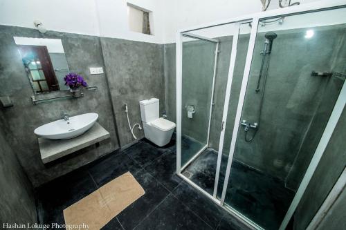 a bathroom with a shower and a sink and a toilet at Serendipity Lake Villa in Panadura