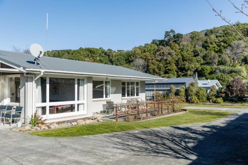 a white house with a mountain in the background at Central, Affordable, Boat Parking - KK18865 in Kaikoura