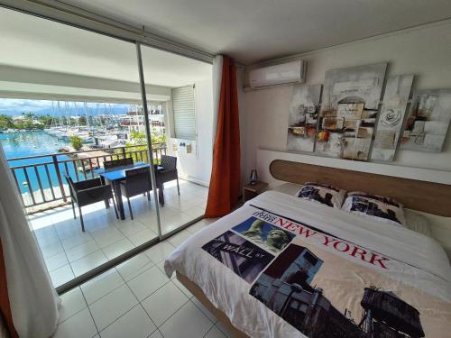 a bedroom with a bed with a view of a balcony at Joli Studio Vue Sur Mer in Pointe-à-Pitre