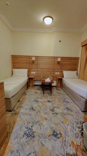 a room with two beds and a rug at فندق نسك الفضيلة in Ajyad