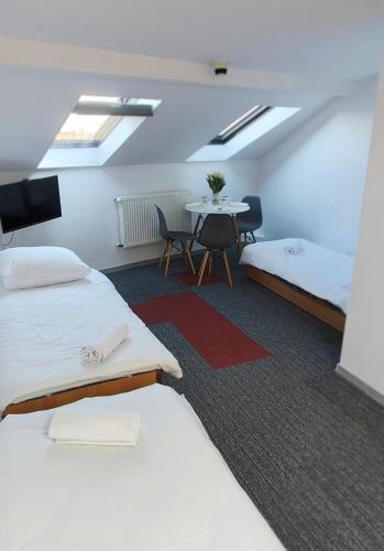 a hotel room with two beds and a table at Noclegi Flauta in Mielno
