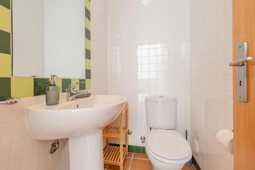 a bathroom with a white toilet and a sink at Retiro do Livro in Óbidos