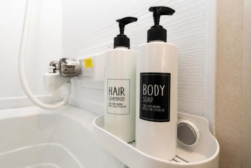 two bottles ofodorizers sitting on a shelf in a bathroom at NaturalfarmZAMPA in Yomitan