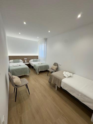 a hospital room with three beds and two chairs at O LAR DE DON BASILIO in Redondela