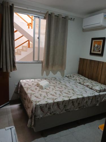 a bedroom with a bed in a room with a window at Suite Vista Mar in Salvador