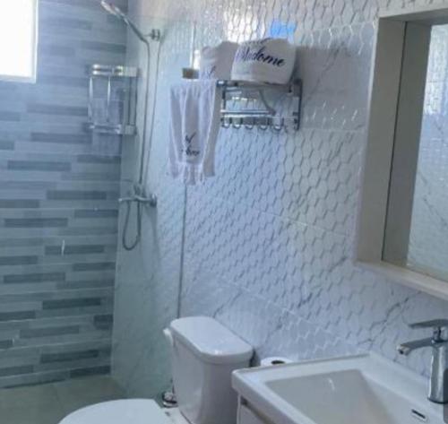 a white bathroom with a toilet and a sink at Casa Same Hotel in Atacames